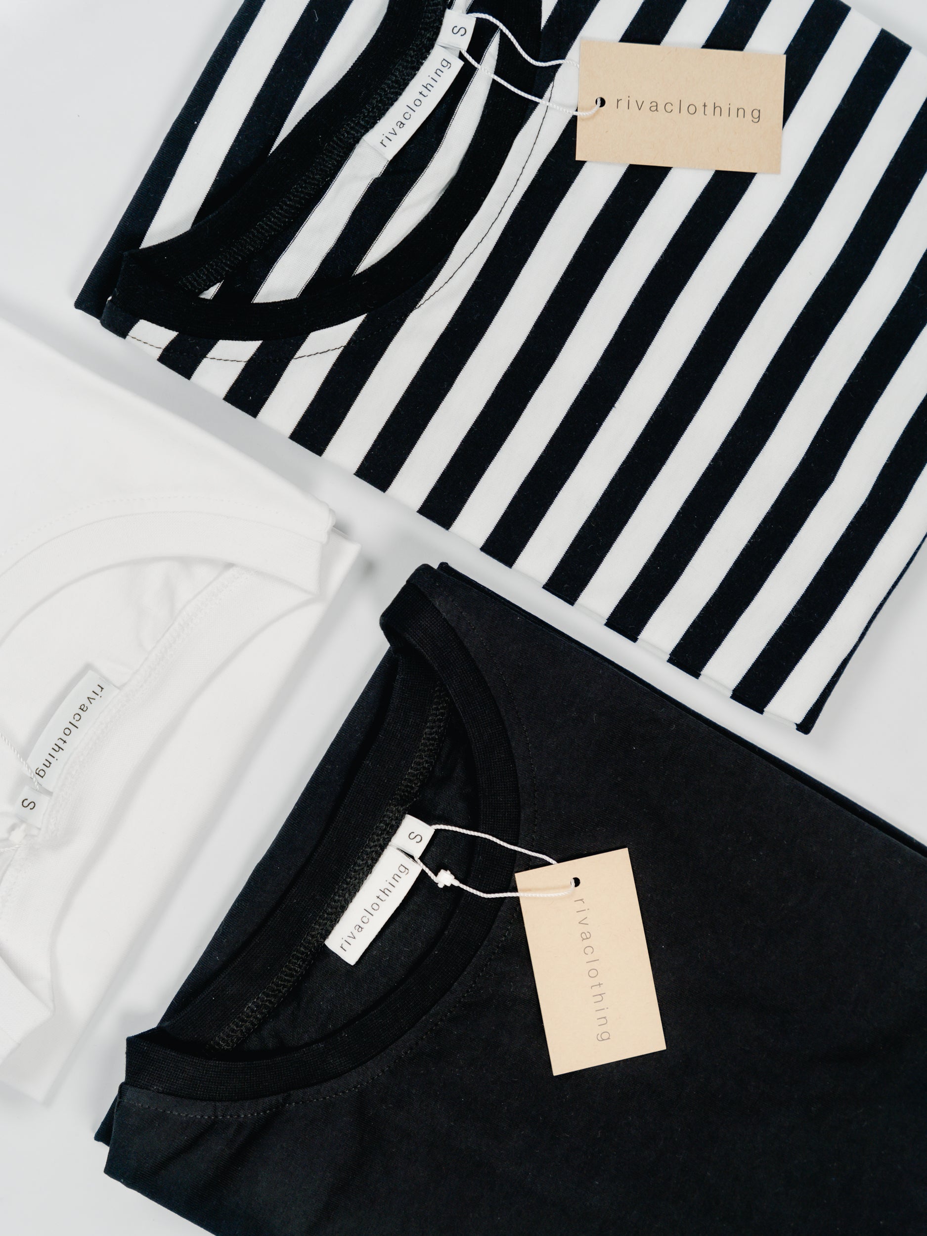 Flatlay kuva mustasta, valkoisesta ja raidallisesta t-paidasta